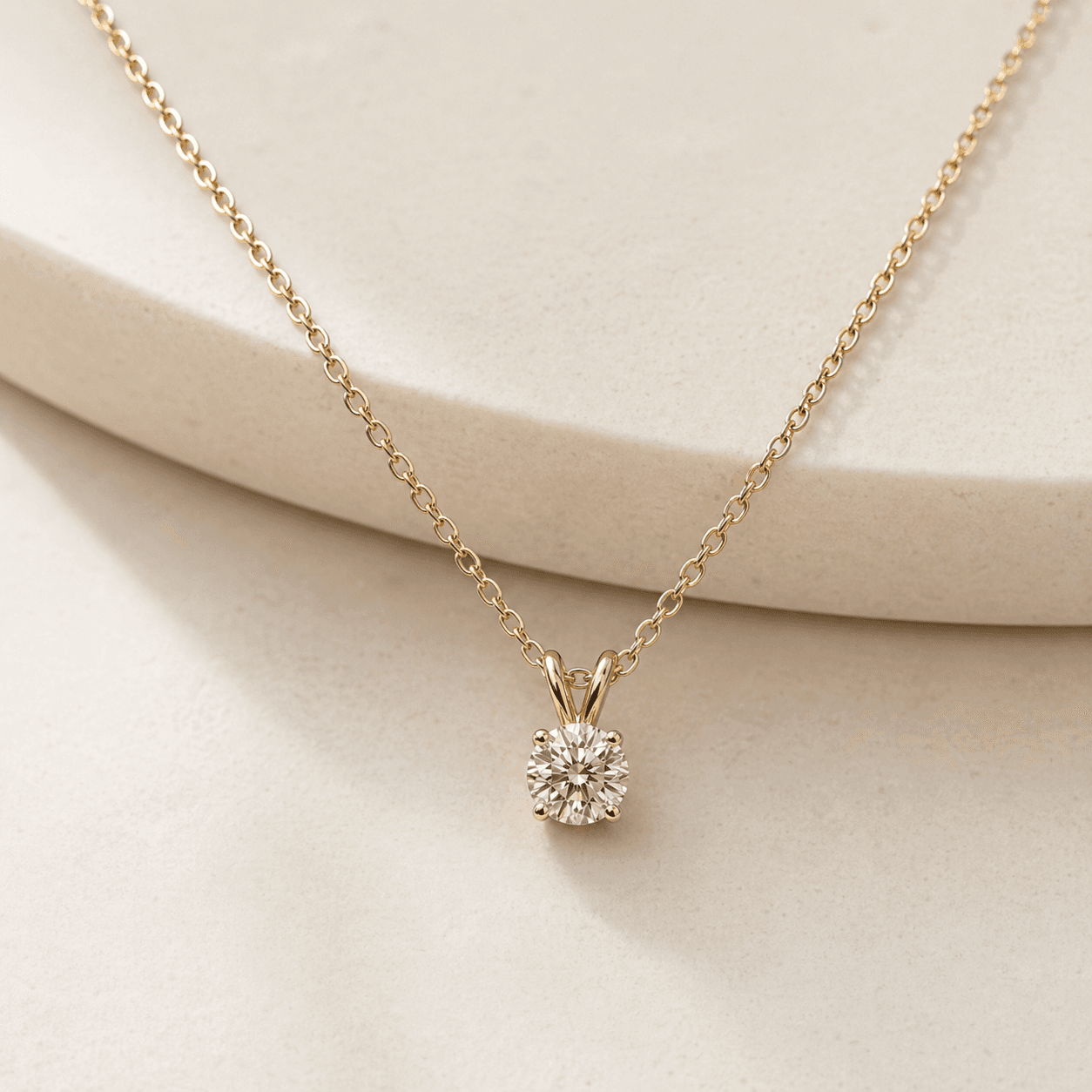 Moissanite pendant necklace on warm ivory background