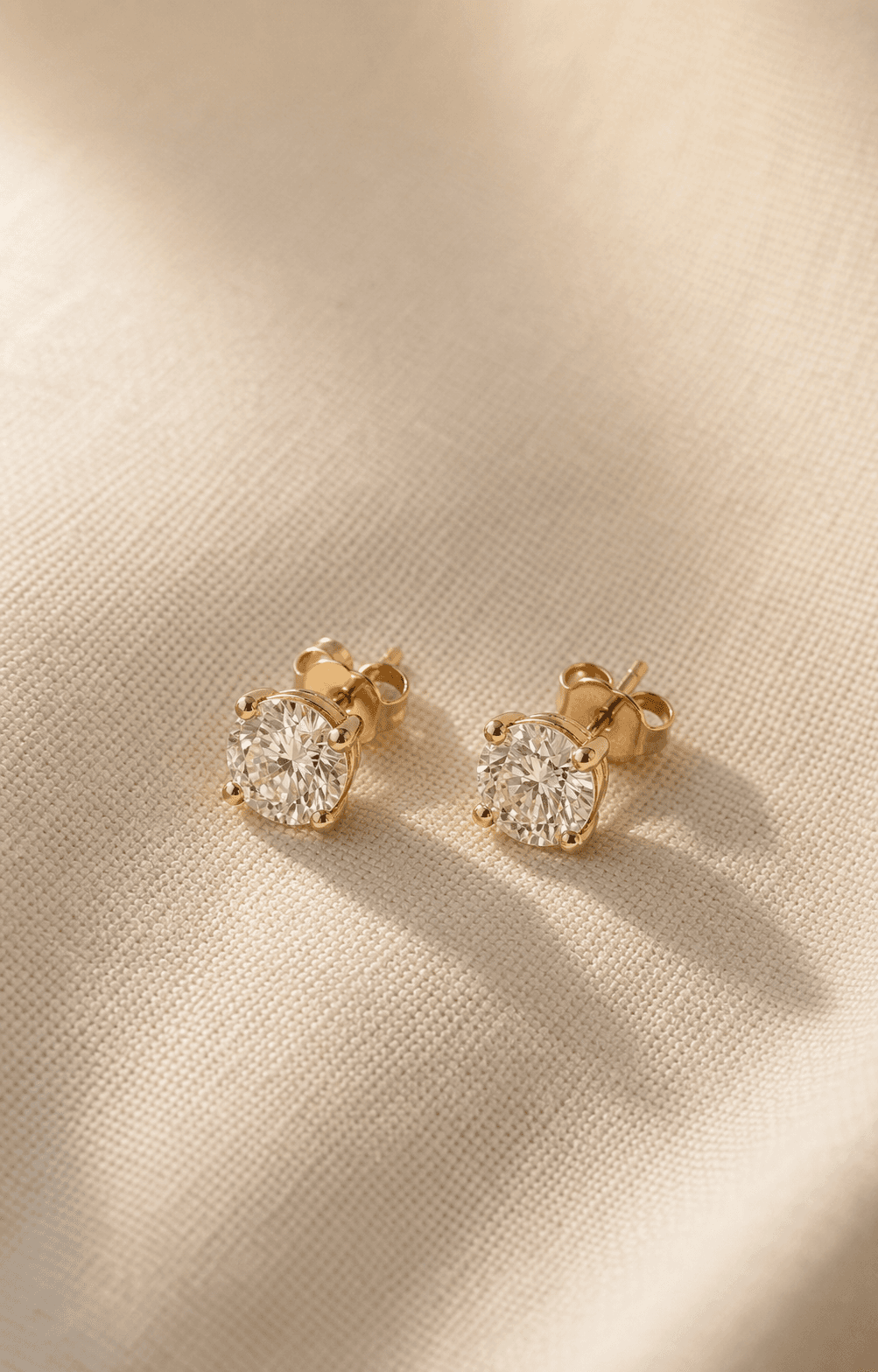 Moissanite stud earrings on warm ivory background